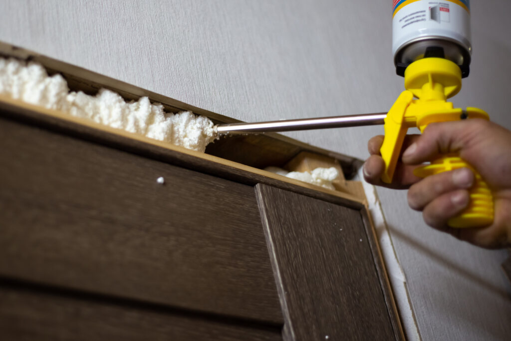 Installation of doors in the house The master foams up the gaps between the door and the wall with polyurethane foam